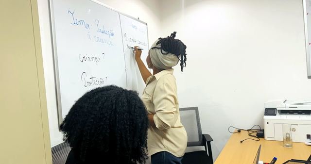 A facilitadora escreve o tema da sessão no quadro